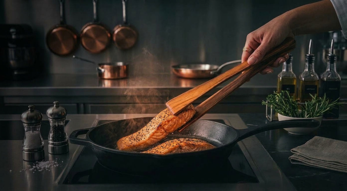 AIR TEAK TONGS lifting a seared salmon fillet from a cast iron skillet